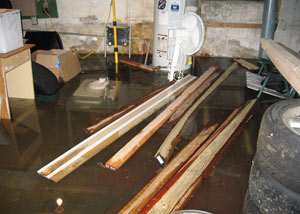 A severely flooding basement in Coe Hill, with lumber and personal items floating in a foot of water